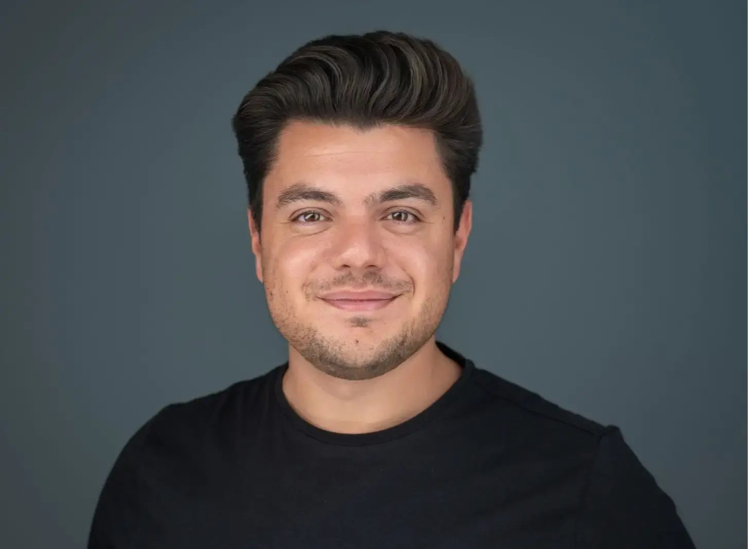 Emanuel Lonz, dein Ansprechpartner bei ComputerSysteme Lonz, blickt in die Kamera. Er trägt ein schwarzes T-Shirt vor einem dunkelgrauen Hintergrund.