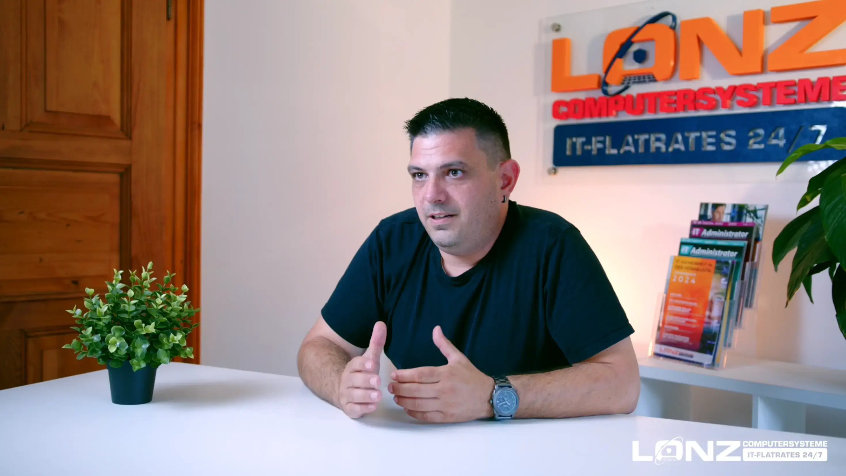 Video-Vorschaubild von Steffen, Mitarbeiter bei ComputerSysteme Lonz. Er sitzt an einem weißen Schreibtisch, spricht und gestikuliert während eines Interviews. Im Hintergrund ist das Firmenlogo zu sehen.